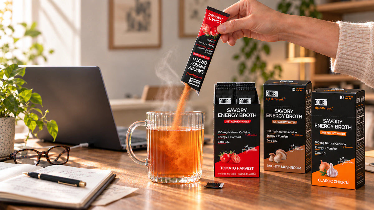 GOBBi Energy Broth pouring into a steaming mug beside Tomato Harvest, Mighty Mushroom and Classic Chick’n boxes.